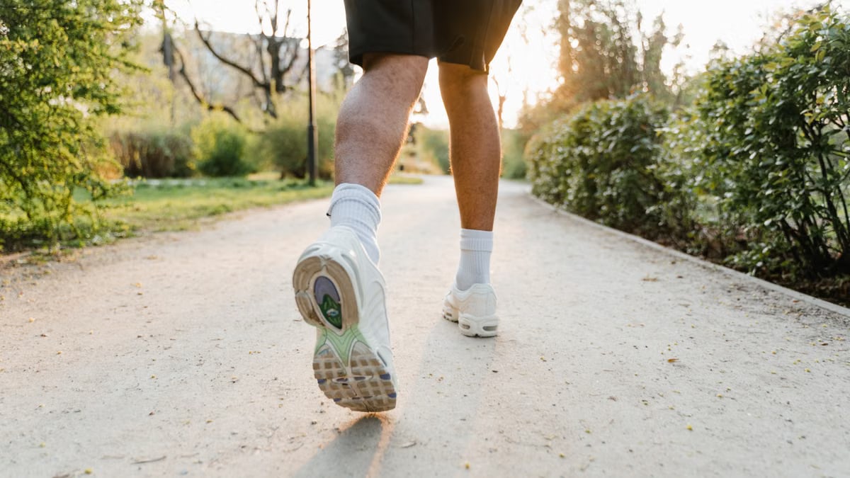 A jogger running on a park path at sunset. Emphasizes fitness and outdoor exercise.